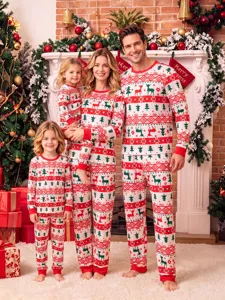 Family christmas matching pajamas detail view showing festive reindeer and tree print pattern.