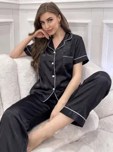 Vue détaillée et élégante de l'ensemble de pyjama en satin noir pour femmes avec passepoil.