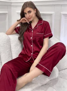 Ensemble pyjama en satin bordeaux avec manches courtes, col tailleur et liserés blancs.