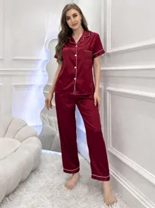 Vue détaillée d'un pyjama en satin rouge pour femme, manches courtes et passepoil blanc.