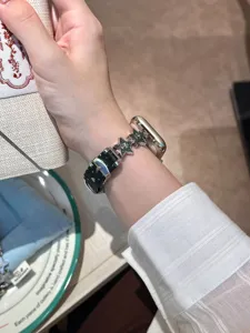Detailaufnahme des schwarzen Lederarmbands mit metallischen Stern-Charms für Apple Watch.