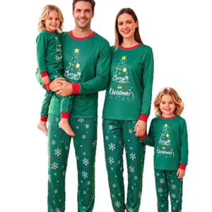Matching family Christmas pajamas set with green long sleeve tops and snowflake print pants.
