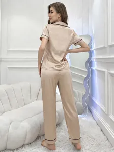 Vue détaillée d'un pyjama en satin lisse avec manches courtes et pantalon long en champagne.