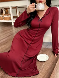Vista detallada del camisón de manga larga para mujer con lazo elegante y borde con ondas.