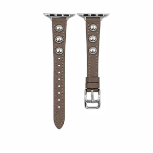 Dettaglio cinturino per orologio in pelle marrone con borchie metalliche e fibbia argento.
