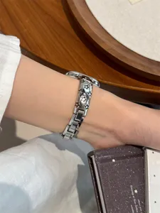 Gros plan détaillé d'un élégant bracelet en métal argenté gravé d'étoiles pour montre connectée.