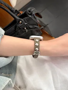 Dettaglio cinturino in pelle con borchie per Apple Watch, accessorio elegante e chic.