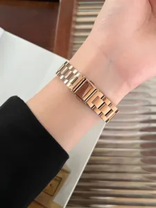 Primo piano dettagliato del cinturino per orologio in metallo oro rosa indossato al polso.