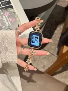 Gros plan sur le bracelet de montre en métal strass étoile scintillant en or rose.