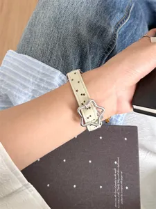 Gros plan sur le bracelet de montre fin en cuir avec des étoiles et une boucle en forme d'étoile.