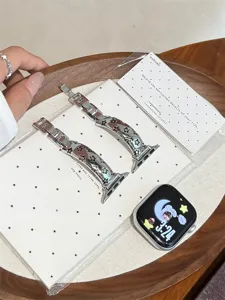 Vue détaillée du bracelet de montre en métal élégant avec des étoiles pour Apple Watch.