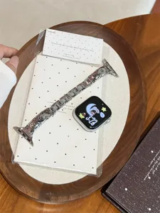 Vue détaillée du bracelet de montre en métal évidé étoile élégant sur plateau en bois.