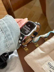 Dettaglio del cinturino per orologio in pelle nera con sfere metalliche eleganti.
