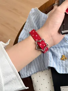 Bracelet de montre en cuir rouge avec étoiles blanches et boucle étoile pour Apple Watch. Détail.