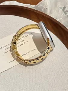 Vue détaillée d'un bracelet de montre étoile en métal doré luxueux pour Apple Watch Series.