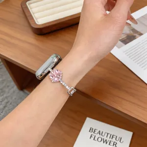 Détail élégant de bracelet de montre en métal incrusté de diamants avec pendentif trèfle rose.
