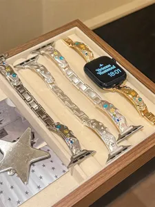 Detailaufnahme des glitzernden Stern Kristall Metall Uhrenarmbands in Holz Schmuckschatulle.