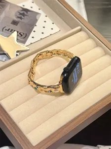 Goldenes Metallarmband Detailansicht mit Strass-Sternen, präsentiert auf einem Samttablett.