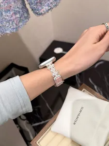 Detailaufnahme des perlenbesetzten Metall-Uhrenarmbands am Handgelenk, edles Design.