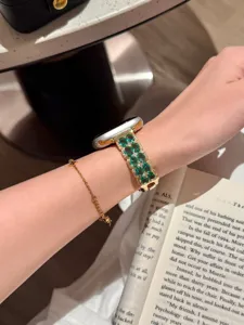 Nahaufnahme des luxuriösen grünen Edelstein- und Diamant-Metallarmbands für Smartwatches.
