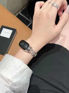 Nahaufnahme eines funkelnden Stern-Strass-Metalluhrenarmbands, elegant am Handgelenk getragen.