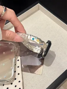 Detailansicht eines eleganten Metallarmbands mit bunten Kristallsternen für Apple Watch.