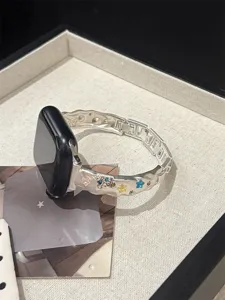 Detaillierte Nahaufnahme des silbernen Metallarmbands mit bunten Strasssternen.