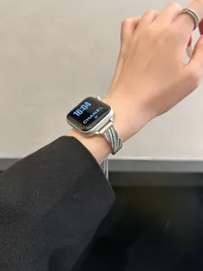 Primo piano dettagliato del cinturino per orologio intrecciato in metallo con strass.