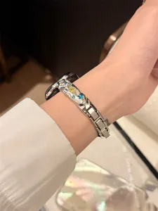 Nahaufnahme des funkelnden Strass-Metallarmbands mit farbigen Kristallsternen im Detail.