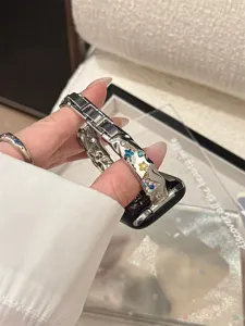 Detaillierte Ansicht des glitzernden Metallarmbands mit bunten Strass-Sternen für elegante Uhren.