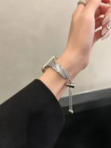 Dettaglio di un elegante cinturino per orologio metallico intrecciato con strass per Apple.