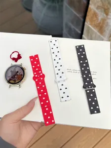 Detail view of stylish silicone watch bands featuring cute heart patterns in red, white and black.