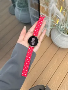 Detail view of red silicone smartwatch strap featuring cute white heart patterns, versatile design.