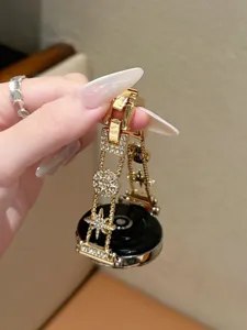 Detailansicht eines luxuriösen vergoldeten Metallarmbands mit funkelnden Strass-Sternanhängern.