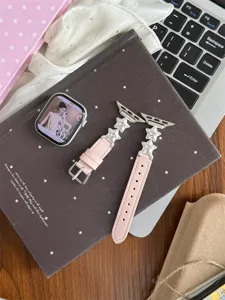 Vue détaillée du bracelet montre en cuir rose avec charms étoiles en zircon pour Apple Watch.