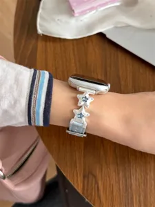Gros plan détaillé du bracelet de montre en cuir bleu clair avec cristaux et étoiles.