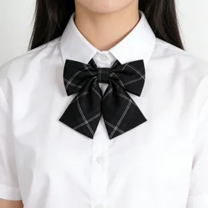 Gros plan sur un nœud papillon pré-noué à carreaux noir et blanc pour uniformes scolaires.