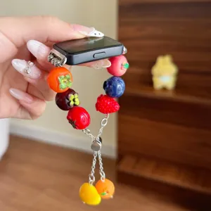 Primo piano del cinturino per orologio in resina fatto a mano con perline di frutta colorate.