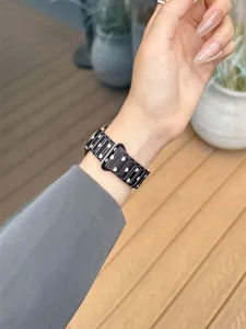 Silicone smartwatch strap detail, stylish black band with white heart pattern for daily wear