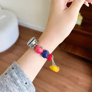 Primo piano del cinturino in resina con ciondoli di perline di frutta e verdura colorati.