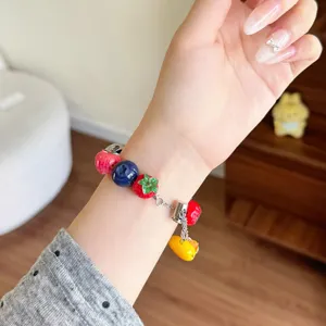 Dettaglio ravvicinato del cinturino per orologio in resina con frutta e bacche colorate.