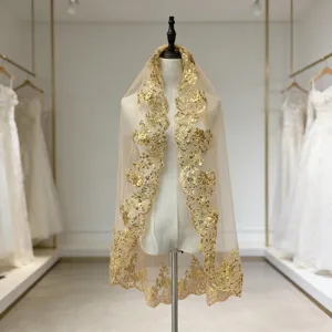 Détail de voile de mariée à sequins dorés avec tissu en maille champagne et broderie fine.