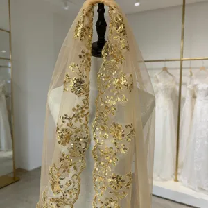 Détail de voile de mariée brodé de sequins dorés, tissu tulle champagne élégant.