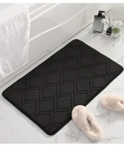 Tappeto da bagno nero spesso in memory foam con motivo geometrico goffrato in dettaglio.