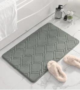 Dettaglio tappetino da bagno geometrico verde con superficie in peluche e fondo antiscivolo.