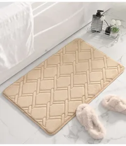 Dettaglio ravvicinato del tappeto da bagno morbido ed ispessito con trama geometrica beige.
