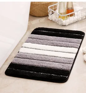 Detailed view of striped non-slip bath mat, soft absorbent plush floor rug for bathroom.
