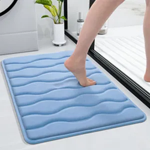 Soft absorbent blue wave bath mat detail shot, non-slip plush floor rug for bathroom doorway.