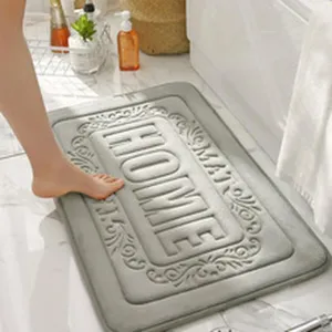 Detail shot of grey embossed anti-slip bath mat with home text in modern bathroom.