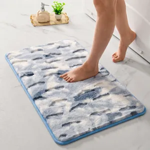 Vista detallada de alfombra de baño de microfibra azul y blanca suave, absorbente y antideslizante.